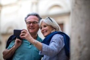 Eldre par som ser på en mobiltelefon Eldre par som ser på en mobiltelefon