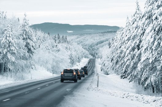 Biler som kjører i kolonne på en vintervei