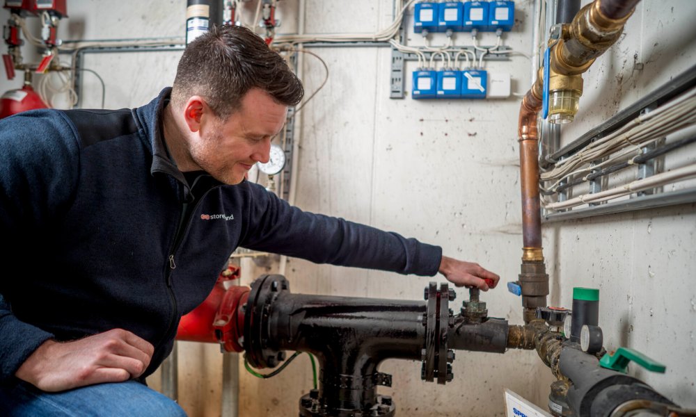 Sondre Zakariassen, risikoingeniør i Storebrand, lukker en stoppekran.