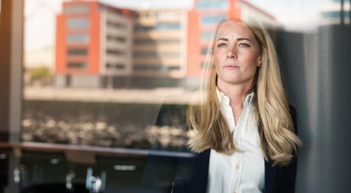Dame i hvit skjorte og blazer som ser ut av et vindu. Dame i hvit skjorte og blazer som ser ut av et vindu.