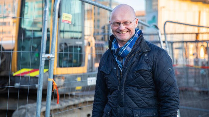 Stein Gunnes, sjeføkonom Maskinentreprenørenes Forbund, foran en gravemaskin.