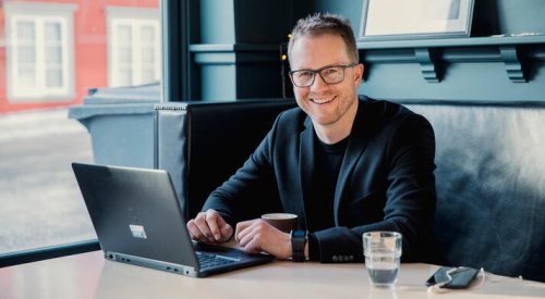 Andreas Østenrød, administrerende direktør i Ressurs Tromsø, i en sofa med en laptop på bordet.