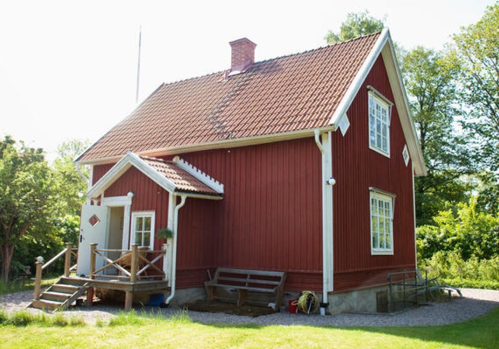 Rød sommerhytte i nydelig sommervær.