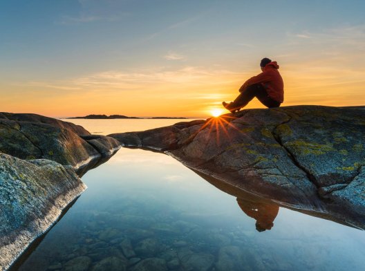 Illustrasjonsfoto: Mann som sitter på et berg i solnedgangen Illustrasjonsfoto: Mann som sitter på et berg i solnedgangen