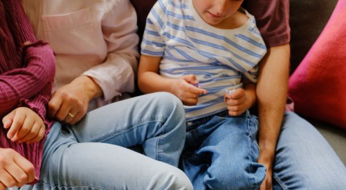 Foto av en familie som sitter samlet tett i en sofa Foto av en familie som sitter samlet tett i en sofa