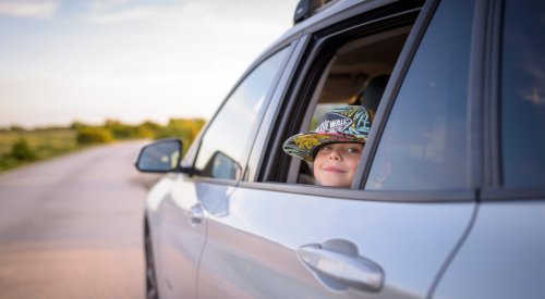 Illustrasjonsfoto: Et barn med caps ser ut av et åpent bilvindu.