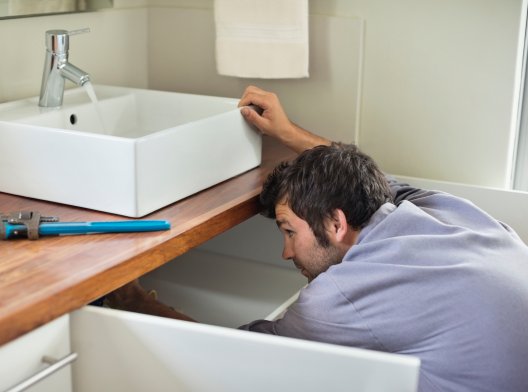 Håndverker som jobber med en vask, illustrasjonsfoto. Håndverker som jobber med en vask, illustrasjonsfoto.