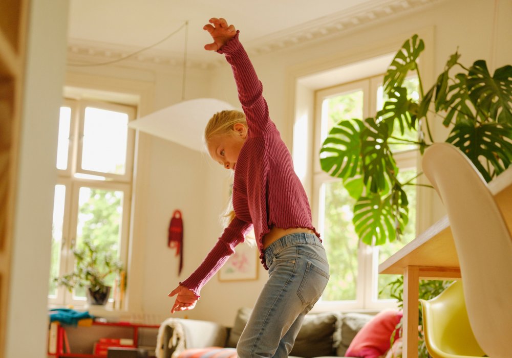En jente som balanserer på et balansebrett i stuen