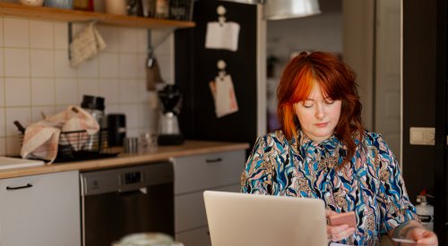 Dame som sitter ved kjøkkenbordet og betaler regninger, illustrasjonsfoto. Dame som sitter ved kjøkkenbordet og betaler regninger, illustrasjonsfoto.