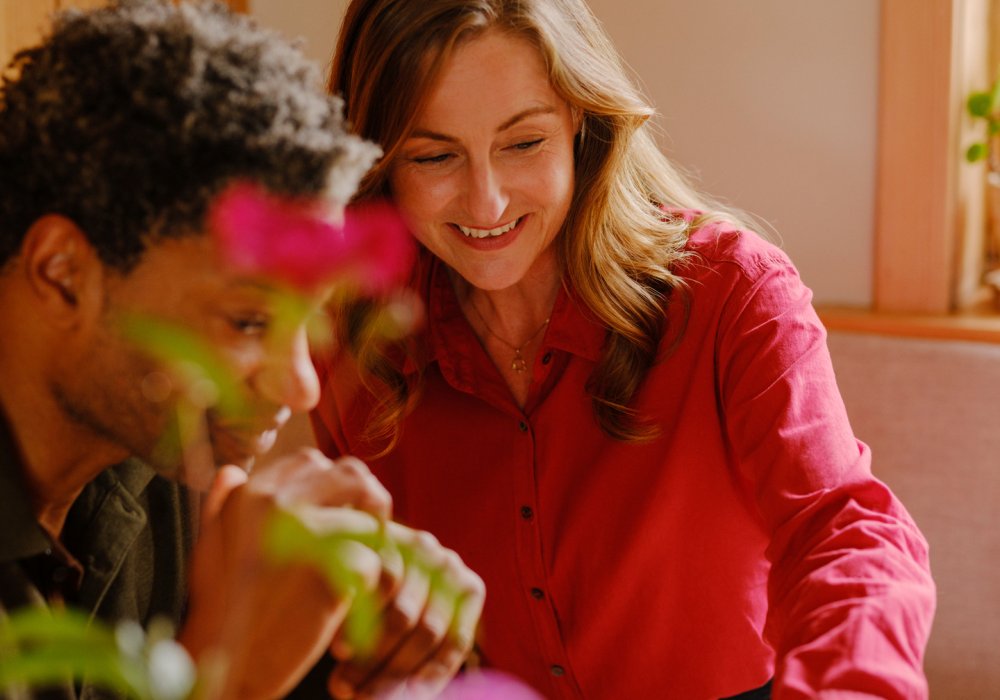 Foto av et par som sitter rundt spisebordet og ser sammen på en pc-skjerm