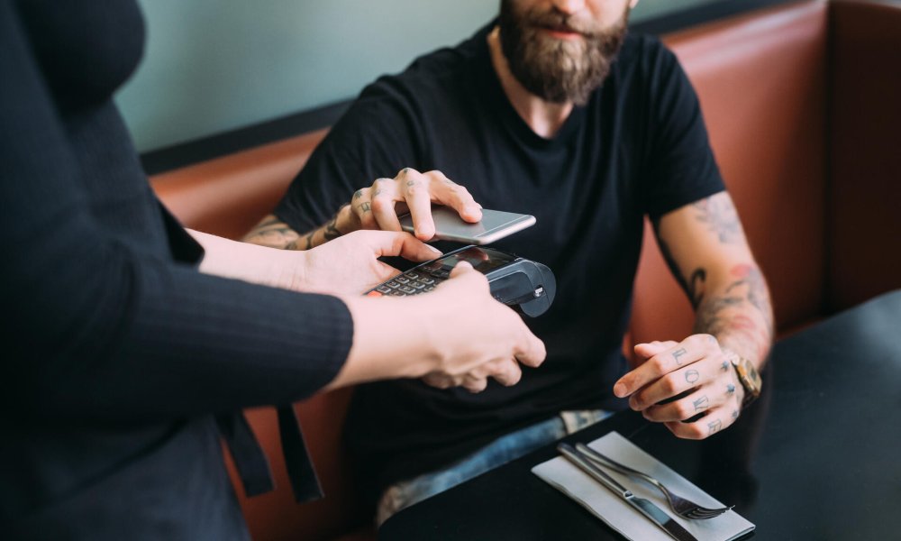Illustrasjonsfoto: Mann betaler med mobil på restaurant. 