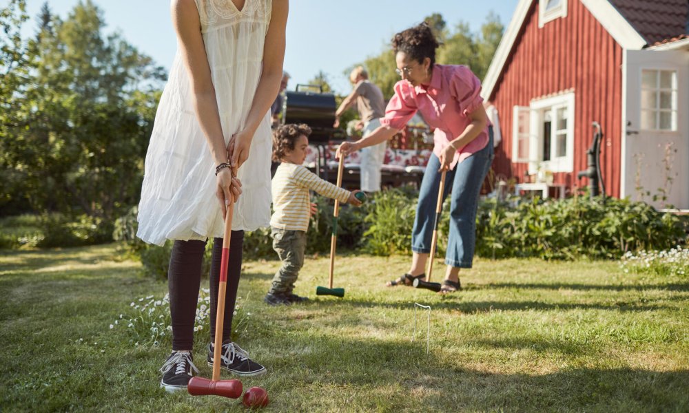 Illustrasjonfoto: Familie spiller krokket i hagen.