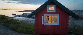 Illustrasjonsfoto: ung kvinne lukker hyttevinduet Illustrasjonsfoto: ung kvinne lukker hyttevinduet