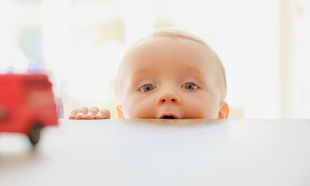 Illustrasjonsfoto: Baby titter over bordkanten.