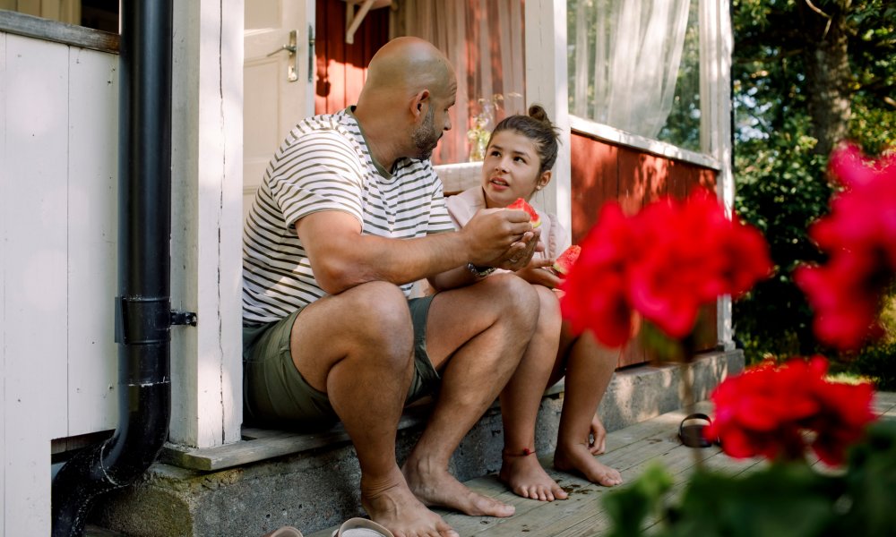 Illustrasjonsfoto: En far og datter sitter på trappa utenfor et hus.