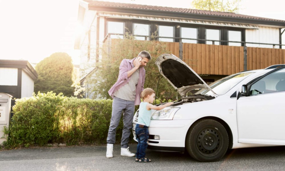 Illustrasjonsfoto: Far og sønn som står foran en bil.