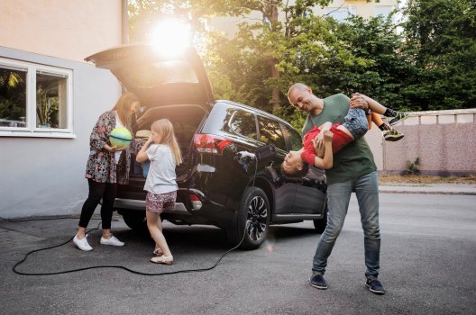 Familie som gjør seg klar til en tur med elbilen