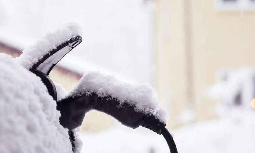 Ladekabel til elbil dekket av snø.