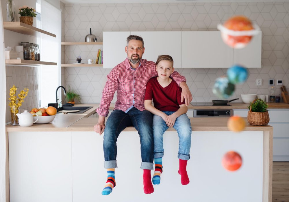 Illustrasjonsfoto: far og sønn sitter på kjøkkenbenken.