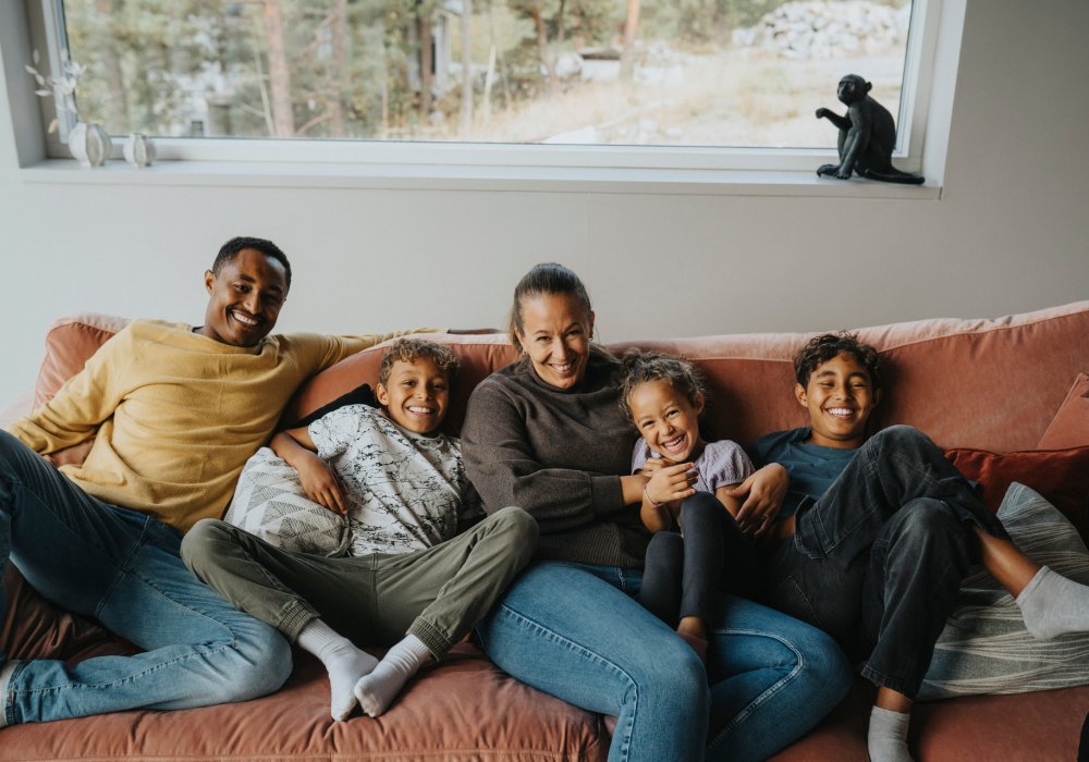 Illustrasjonsfoto: hele familien samlet i samme sofa.