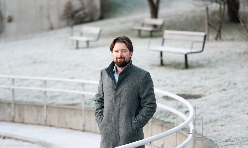 Portrett av Joar Hagatun utenfor Storebrands lokaler på Lysaker på vinterstid med snø på bakken