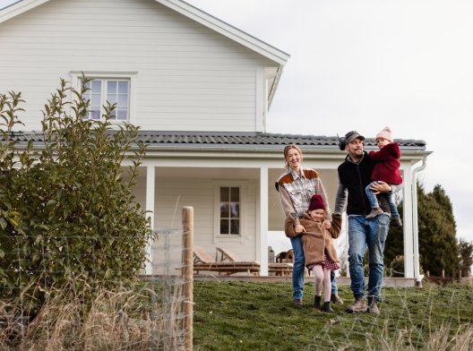 Illustrasjonsfoto: Familie i hagen forran huset sitt Illustrasjonsfoto: Familie i hagen forran huset sitt