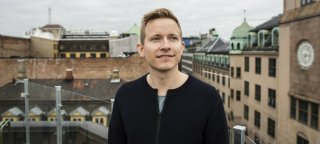 Portrettfoto av mann på toppen av Oslos tak. 