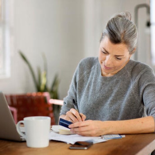 Kvinne med grå genser noterer i en notisblokk Kvinne med grå genser noterer i en notisblokk