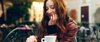 Dame på kafé som drikker kaffe og sjekker mobilen. Dame på kafé som drikker kaffe og sjekker mobilen.