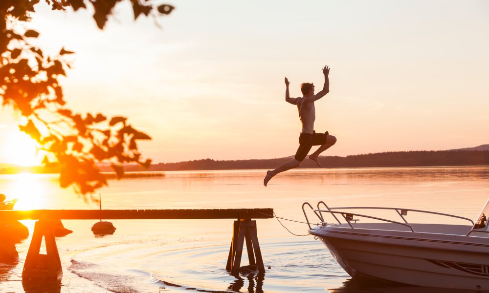 Illustrasjonsfoto: Mann hopper i havet fra brygge i solnedgang. 