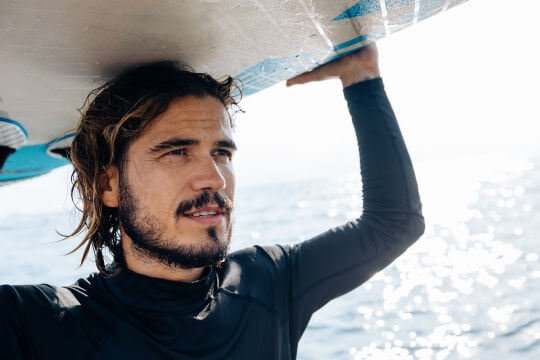Mann_med_surfebrett_540x360